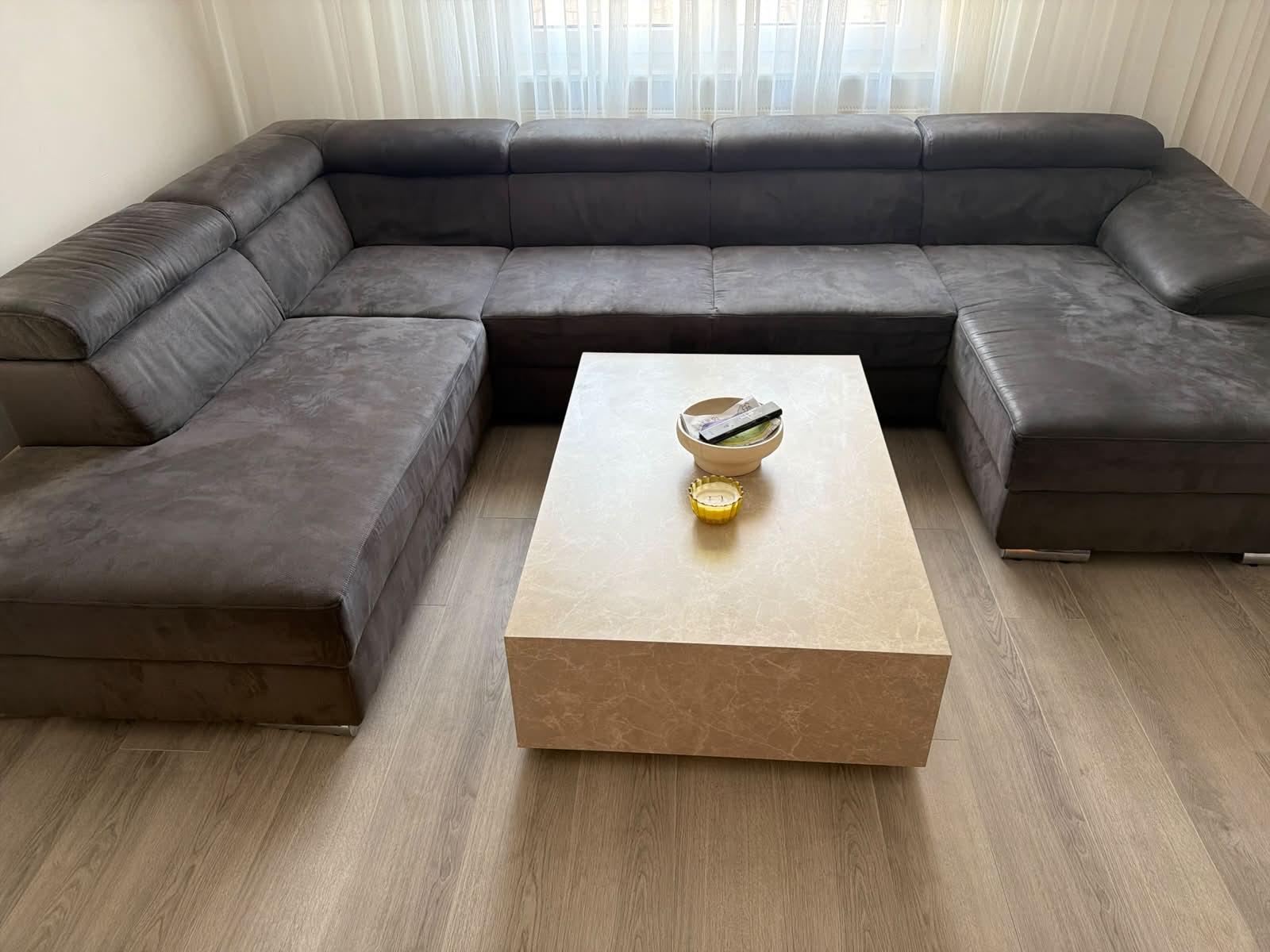 Ich biete hier meine geräumige Wohnlandschaft mit Schlaf funktion in einer schlichten, dunkelgrauen Optik an, die viel Platz für gemütliche Stunden bietet. Das Sofa ist in U-Form gestaltet und fügt sich durch