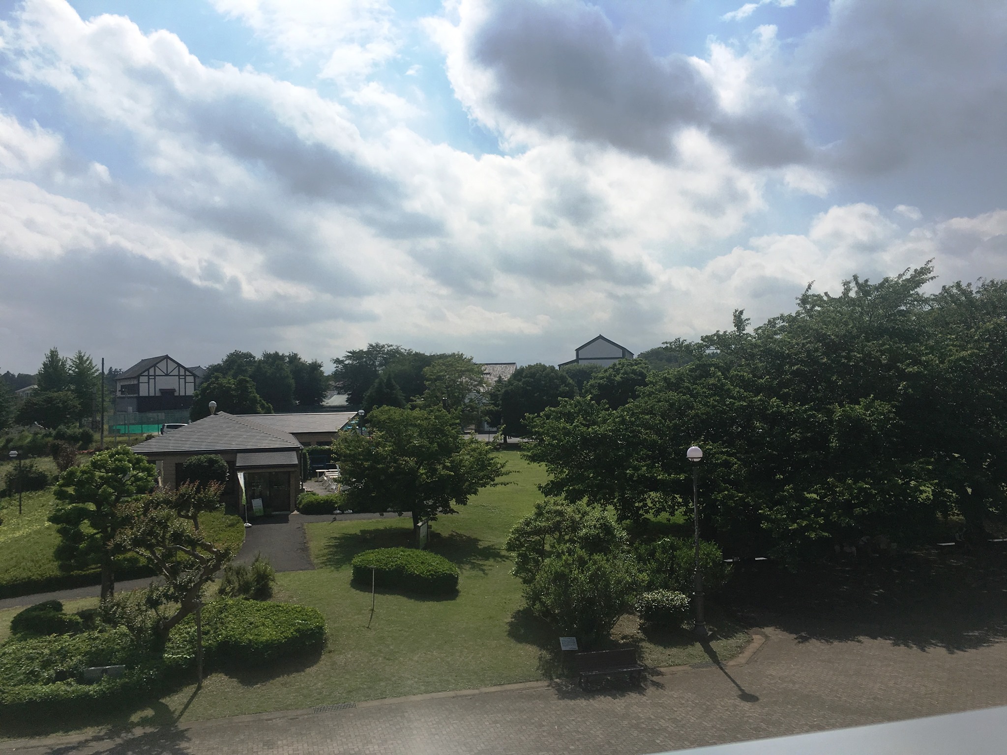 入間市博物館 アリット 当館の穴場スポット バルコニーからの景色です 眩しすぎるので暗めに撮影しました 嵐が近づいているわけではありませんのでご安心を レストランの向こうに 見える建物は アメリカの建築家クリストファー アレグザンダーによる 盈進学園
