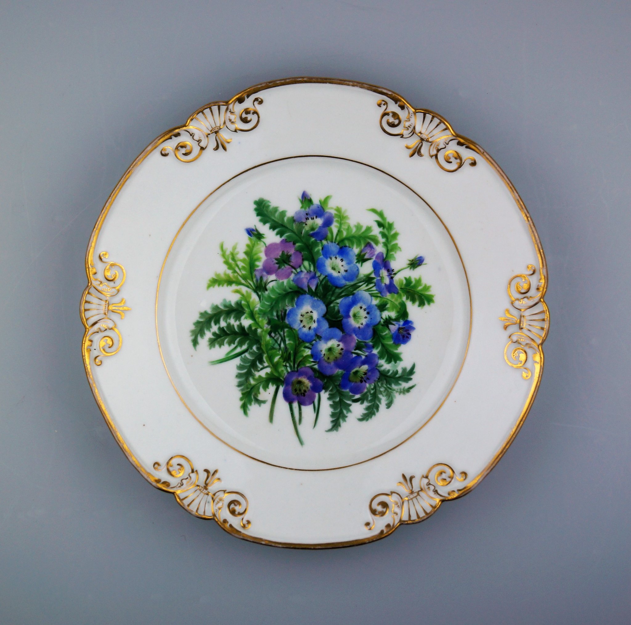 Collectible porcelain plate is blue and white. This hand-decorated 