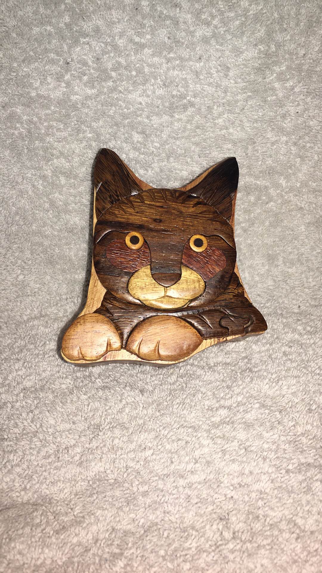 Handcrafted wooden puzzle box is shaped like a cat with a striped
