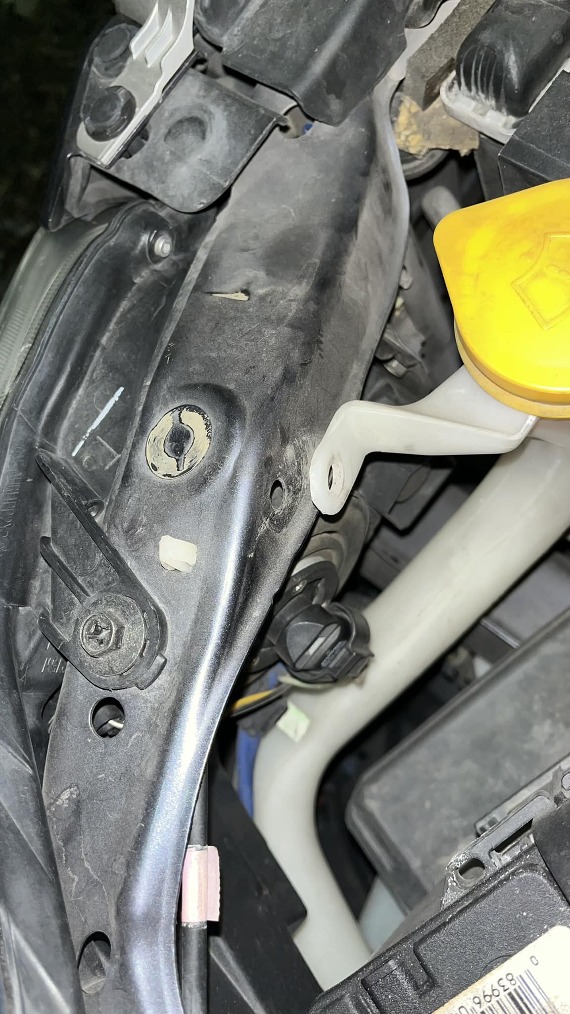 What part secures the windshield wiper fluid reservoir?
