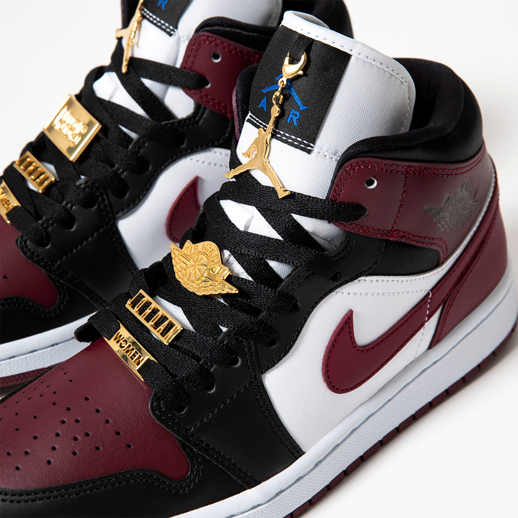 golden pendants decorate the Wmns Air Jordan 1 Mid 