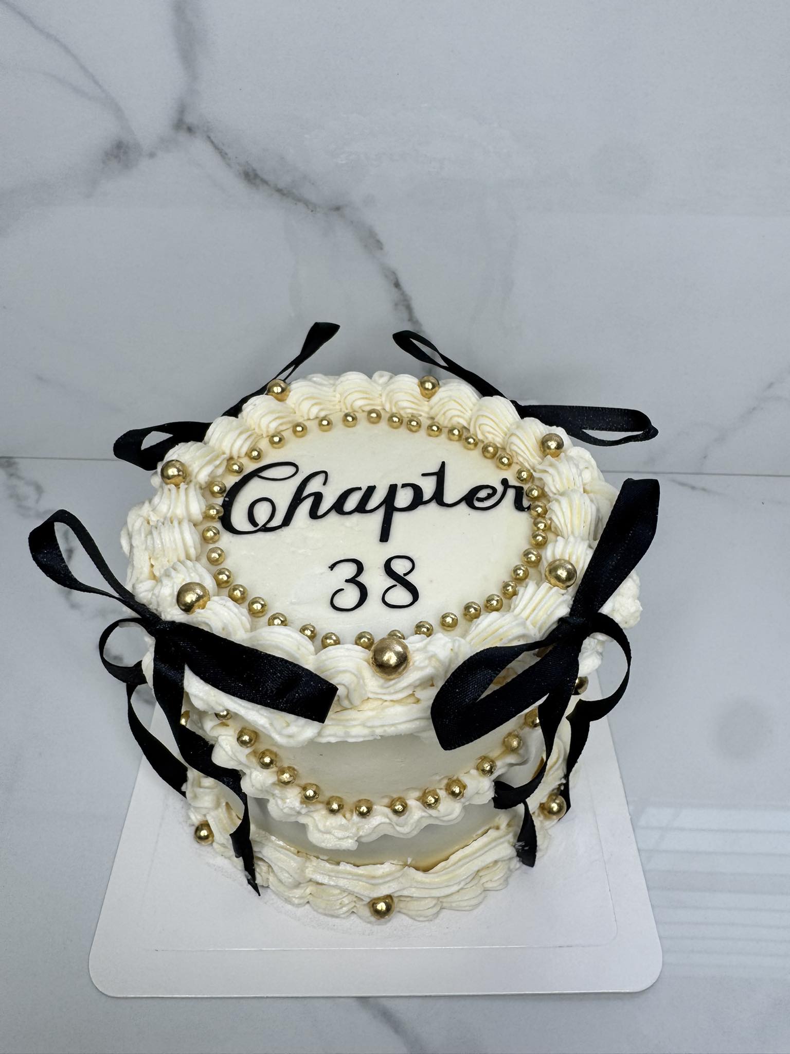 Black and cream cake with gold pearls