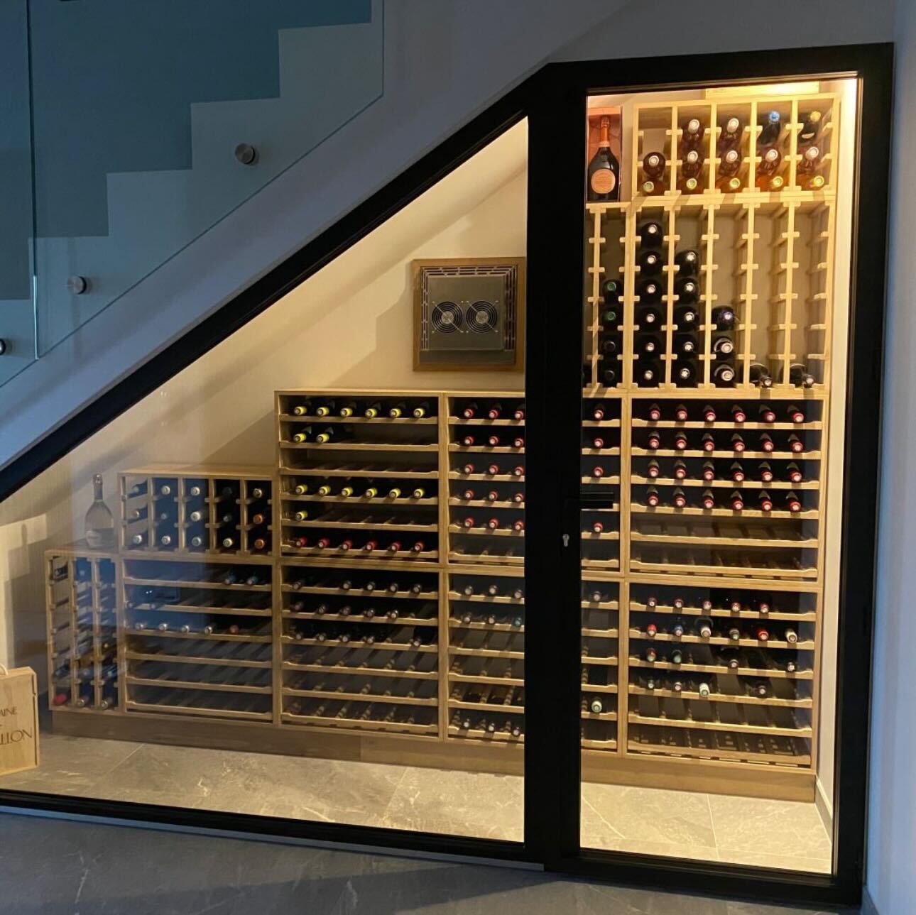 Träumst du von einem stilvollen Weinzimmer unter der Treppe?🍷✨ Dieses schicke Weinzimmer verfügt über Eichenholz-Weinregale von Caverack – perfekte Raumnutzung und ein wunderschönes Zuhause für deine
