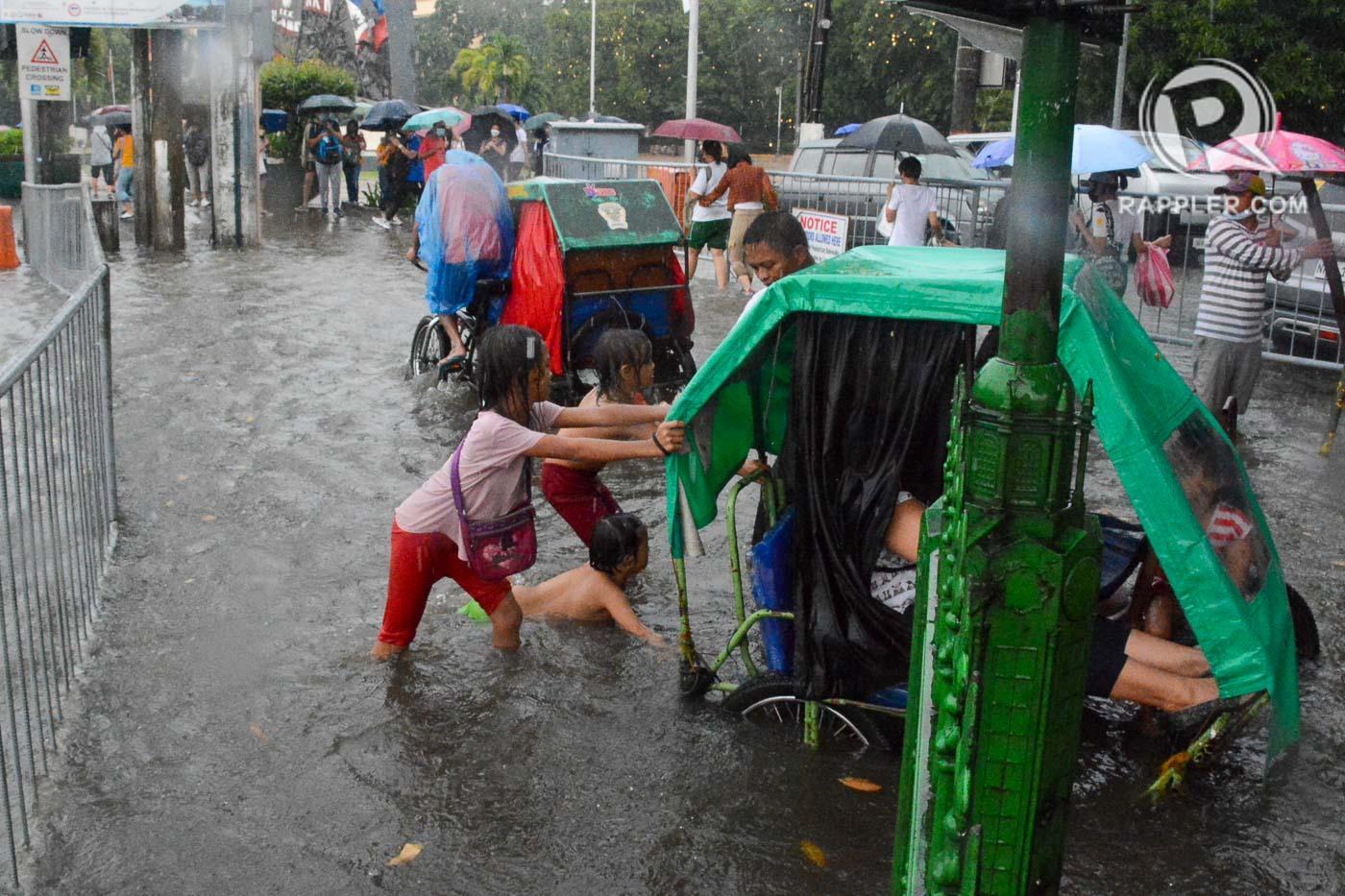Rappler - Pedestrians and children wade through flooded... | Facebook