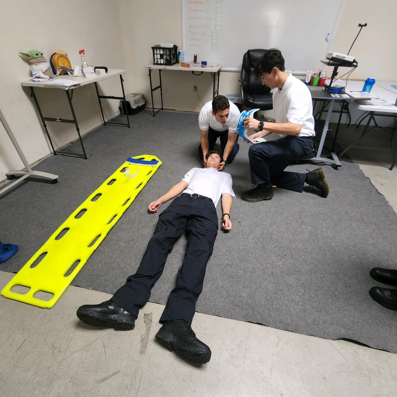 Learning how to use a backboard and... - American EMT Academy