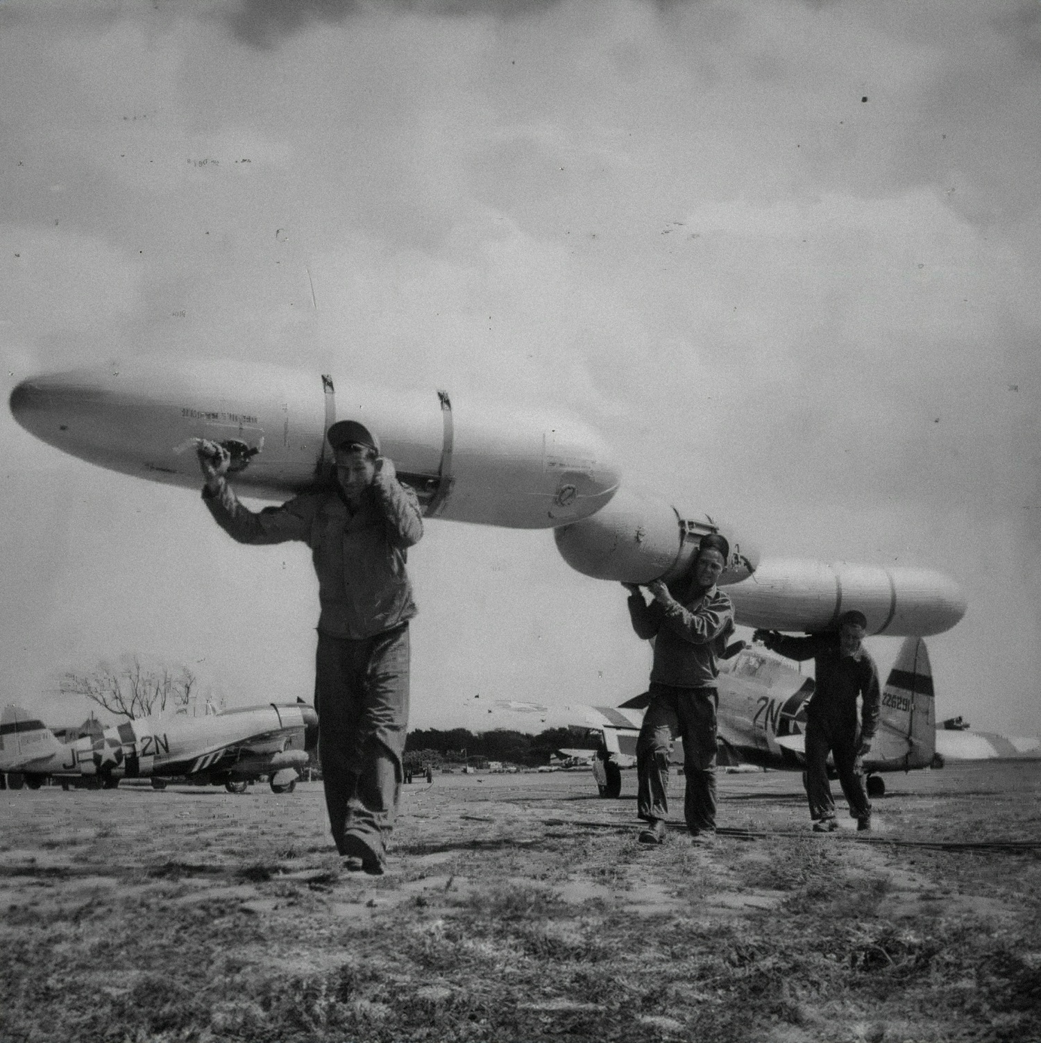 World - Ground crewmen haul 108-gallon fuel drop tanks across a P-47 ...