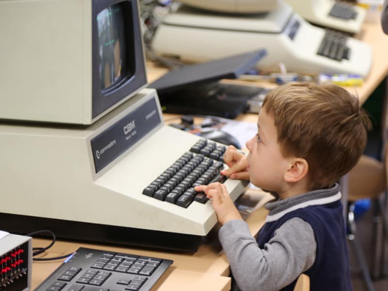 Boy plays with vintage CBM home computer at retro fair