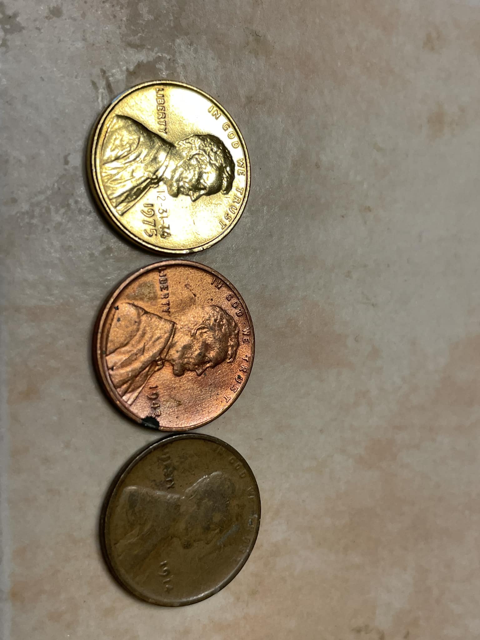 The penny on the left has a gold tone to it. It weighs 2.51 grams 