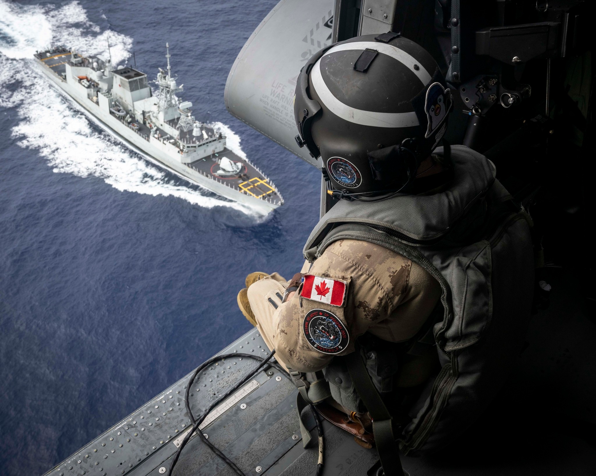 Canadian - An Airborne Electronic Sensor Operator sits in the door of # ...