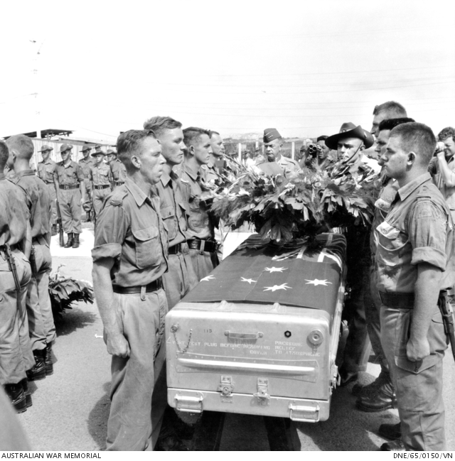 Regimental - Pall bearers stand next to a coffin, draped with the ...
