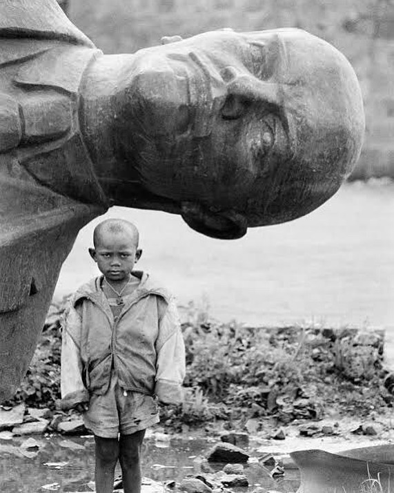 Past - A boy standing in front of fallen statue of Lennin Meskel Square ...