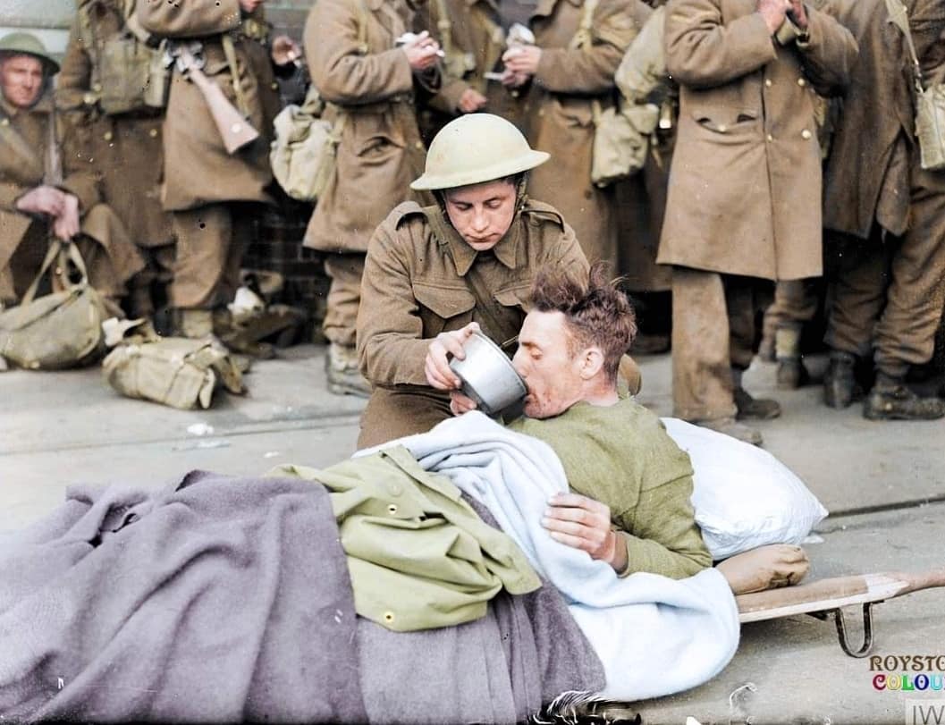 Vito - A wounded British soldier on a stretcher is given a drink on the ...