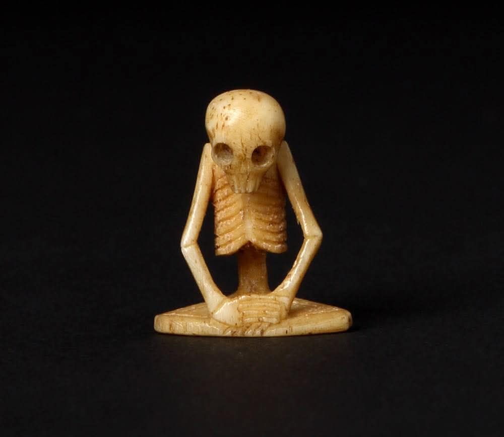 This delightful object is an ojime in the form of an aubergine. It