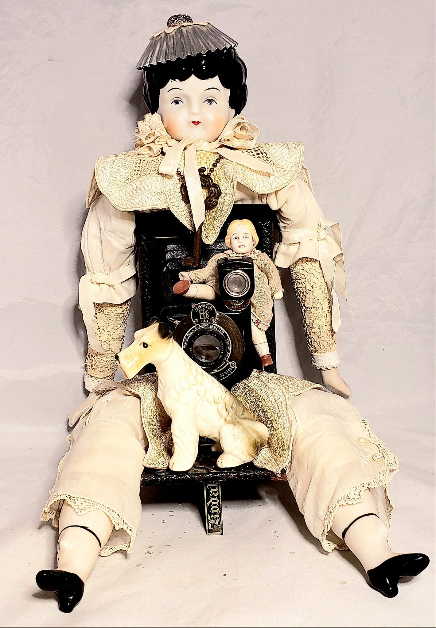 Vintage china doll assemblage with antique camera body