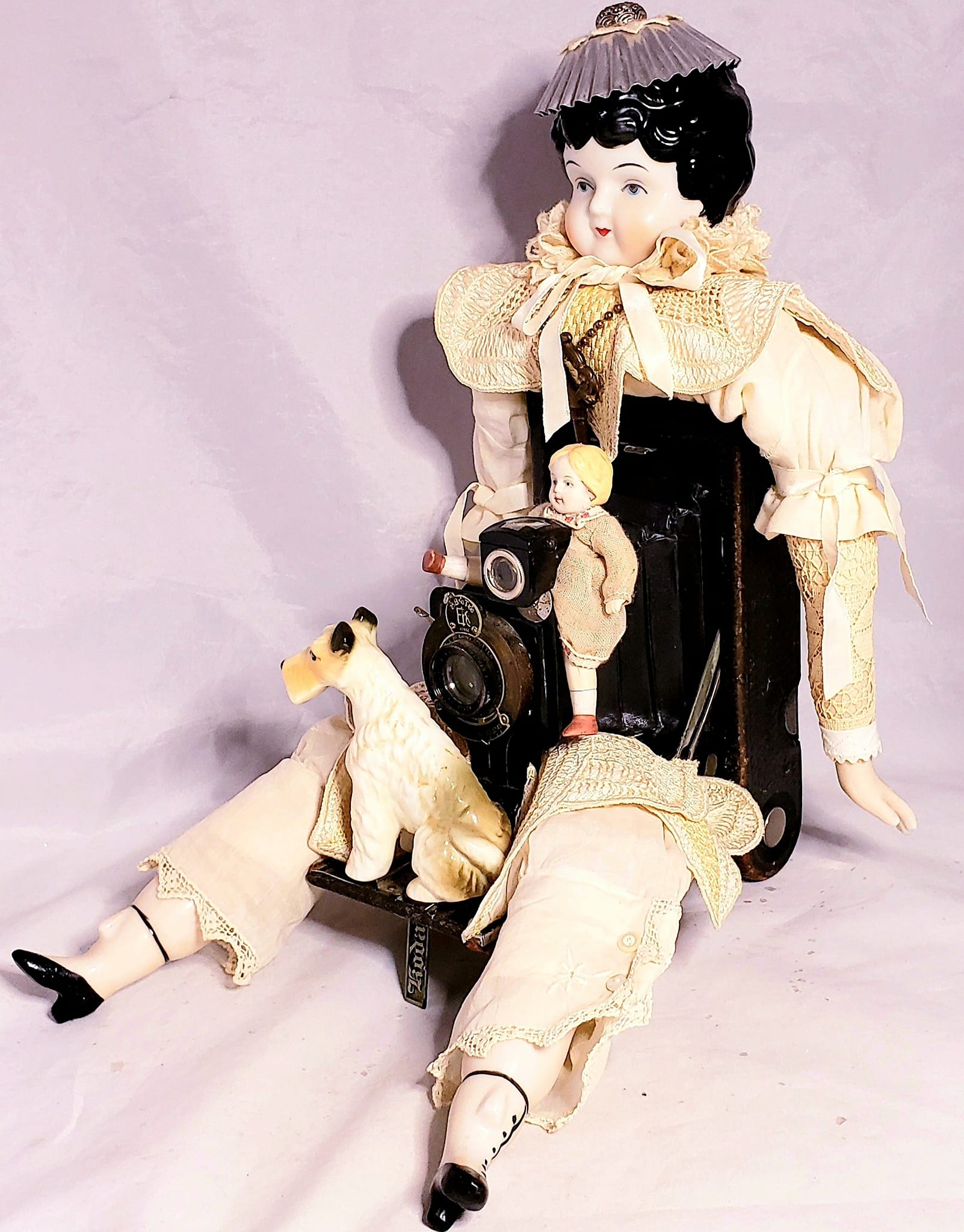 Vintage china doll assemblage with antique camera body