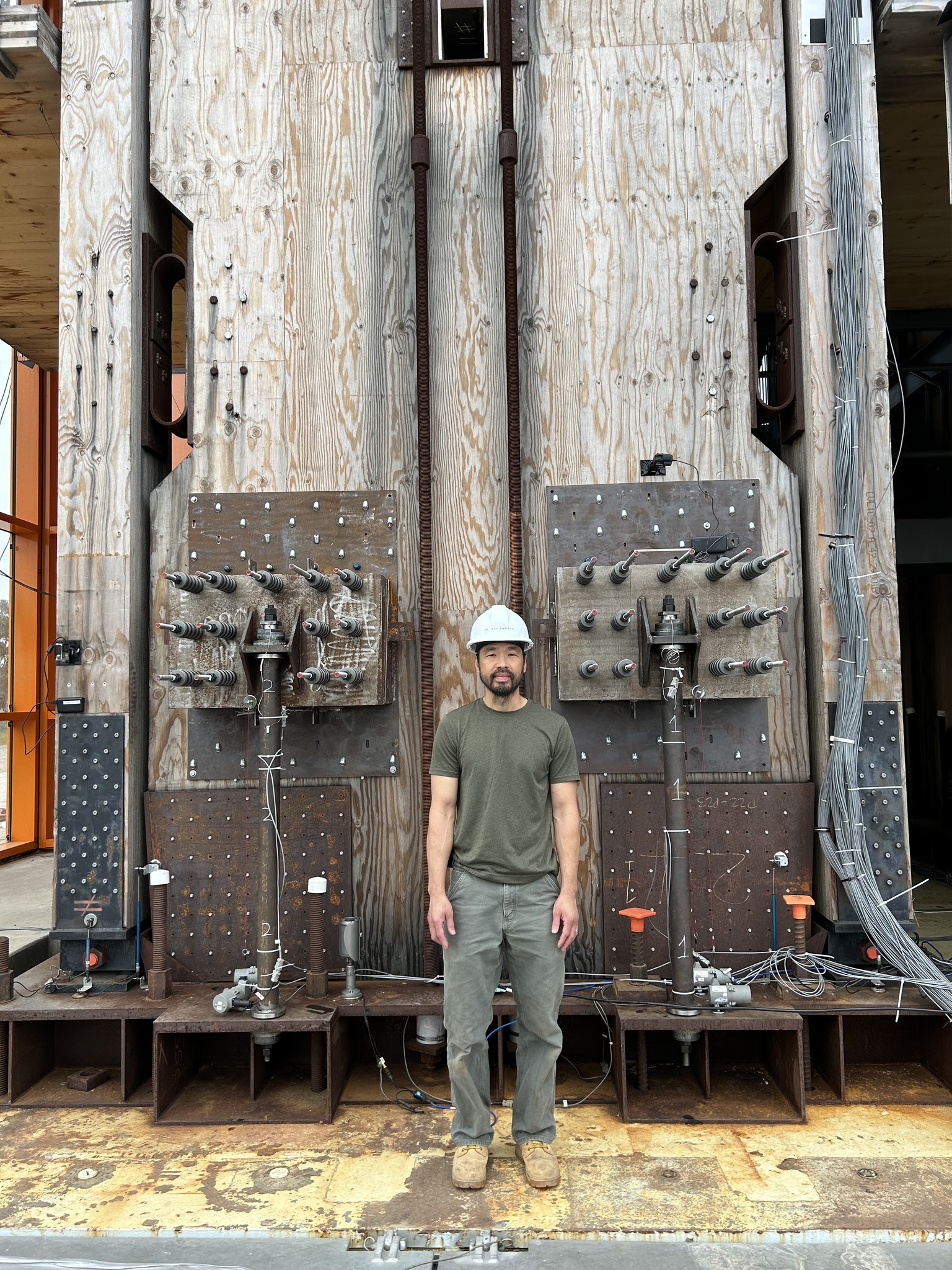 Dr. Daniel Dowden stands at one of the mass timber rocking walls with ...