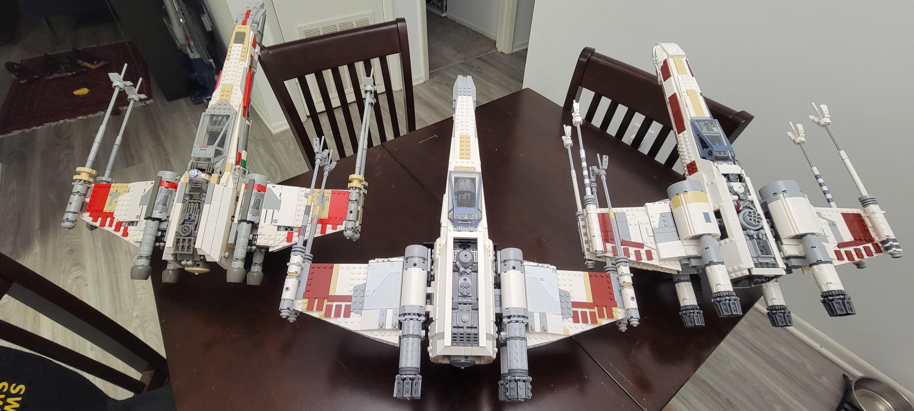 All three LEGO UCS X-wing sets side by side. Left to right: 2000