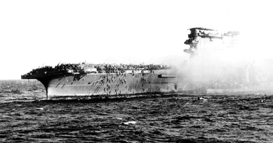 U.S. sailors abandon the aircraft carrier USS Lexington after she