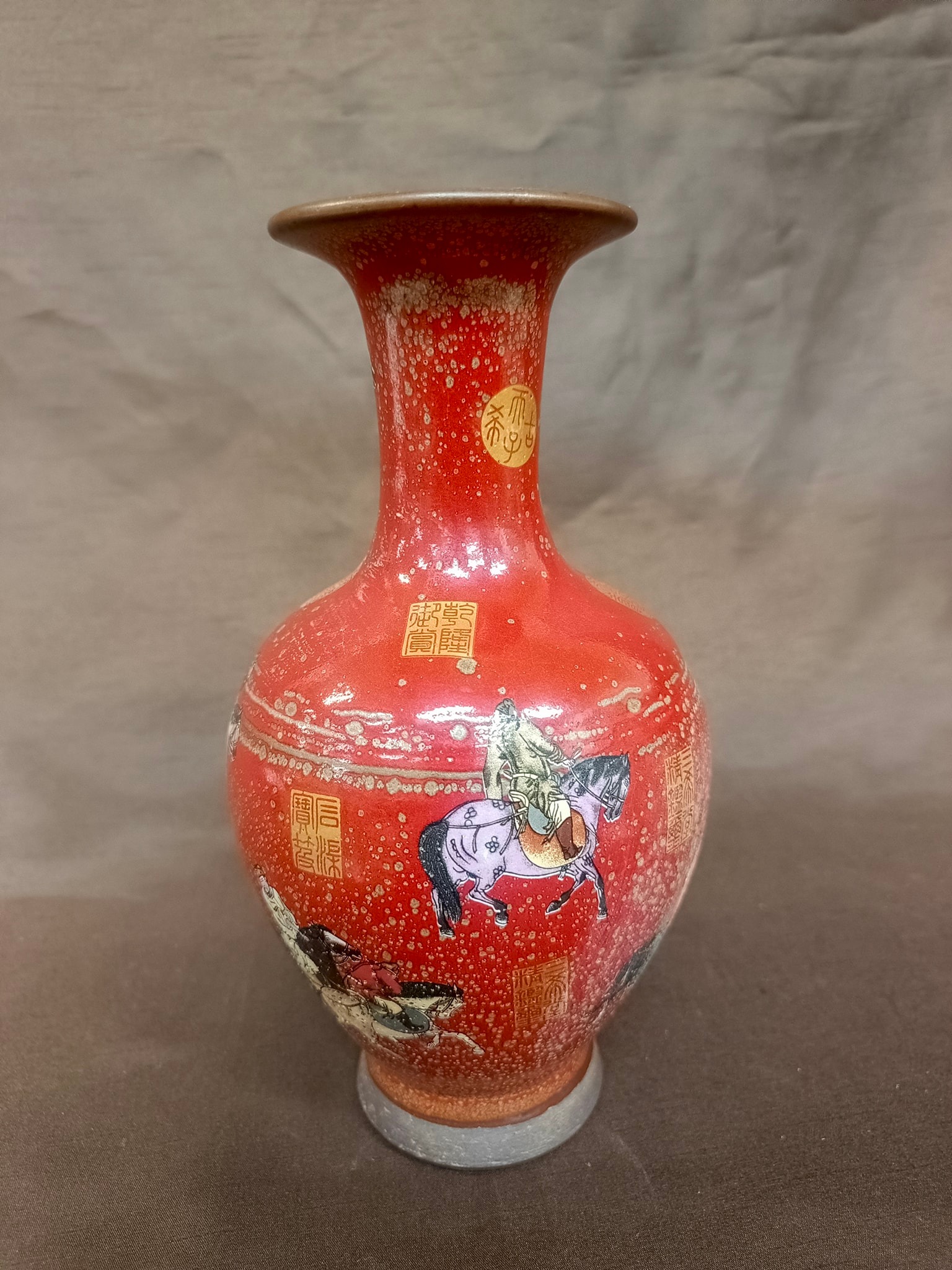 清光绪珊瑚釉粉彩描金人物瓶。 图片展示的是一个红色的花瓶，其特点和