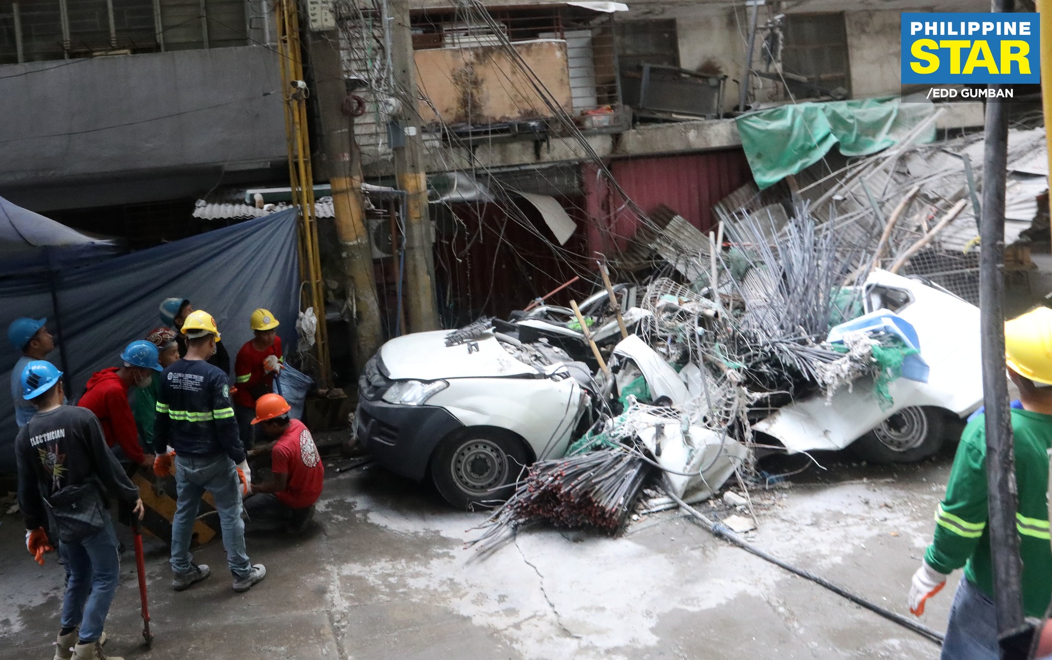 Philippine - Workers clear out steel bar debris after falling off a ...