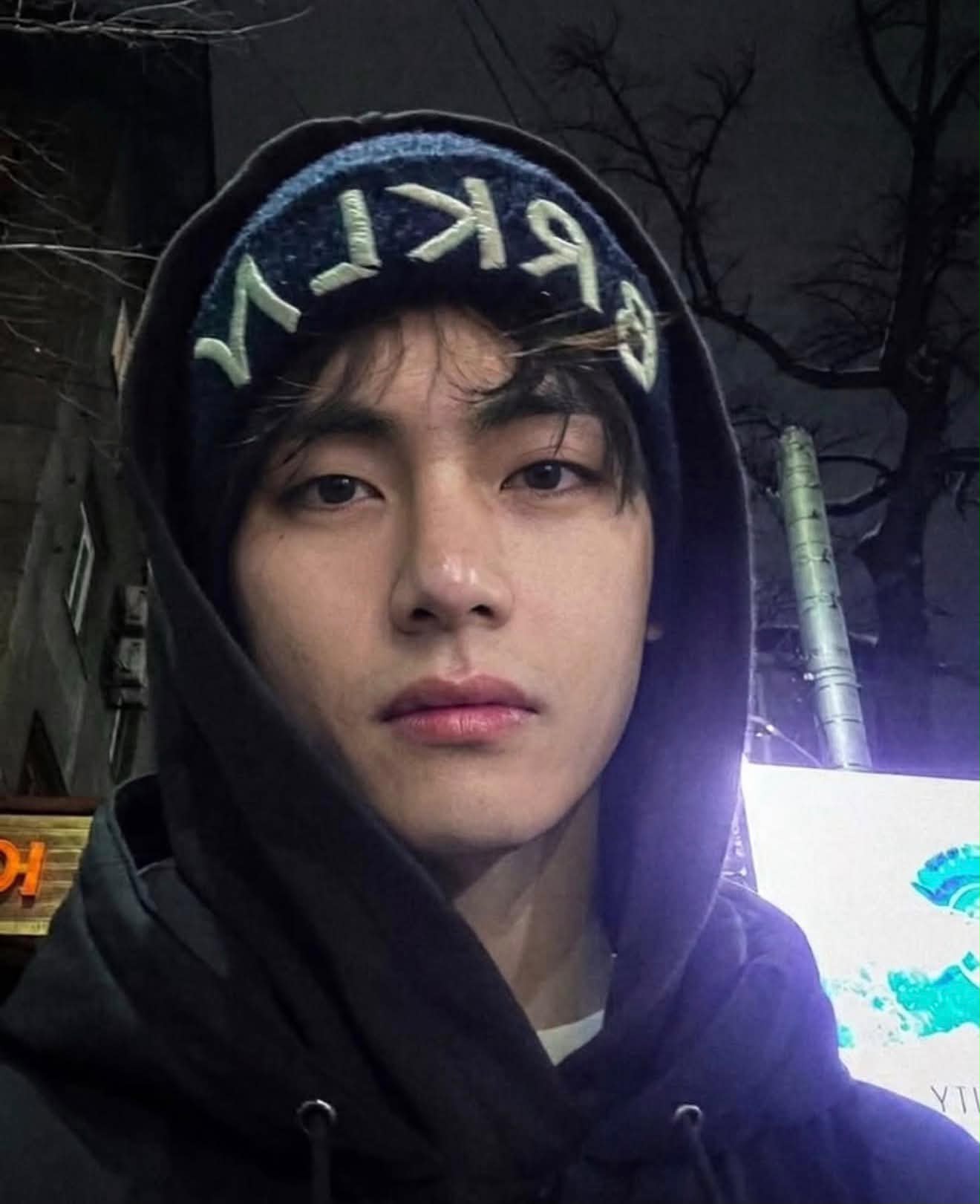BTS member V takes a close-up outdoor selfie at night while 