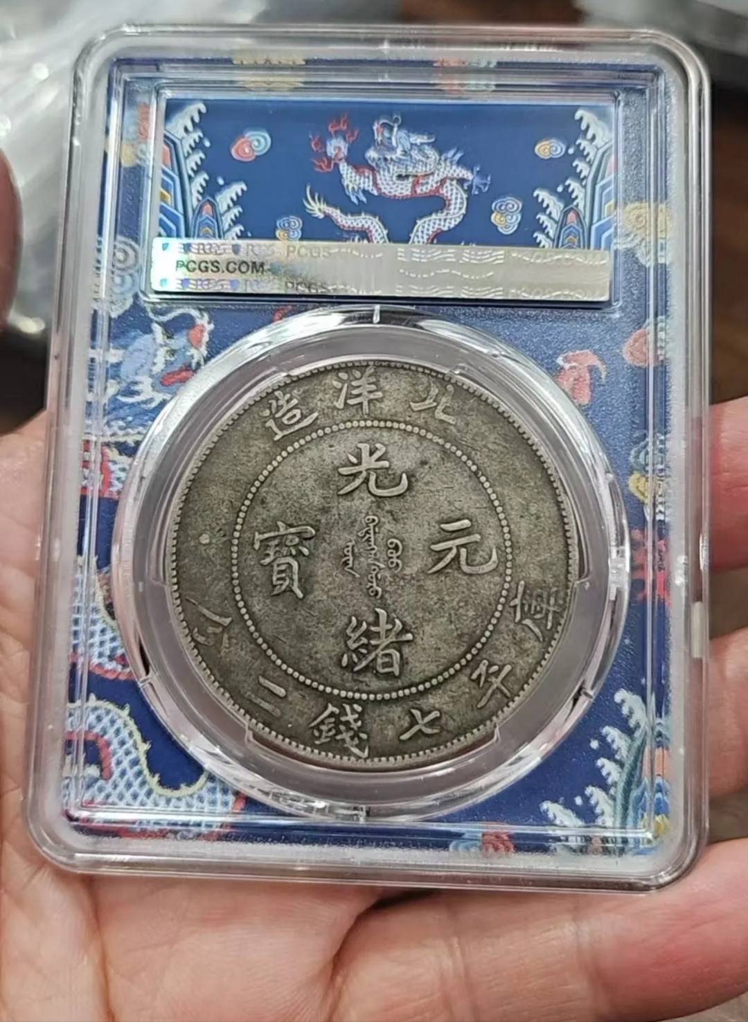 这是一枚北洋造34年光绪元宝七钱二分银币（长尾龙版），由PCGS评级为