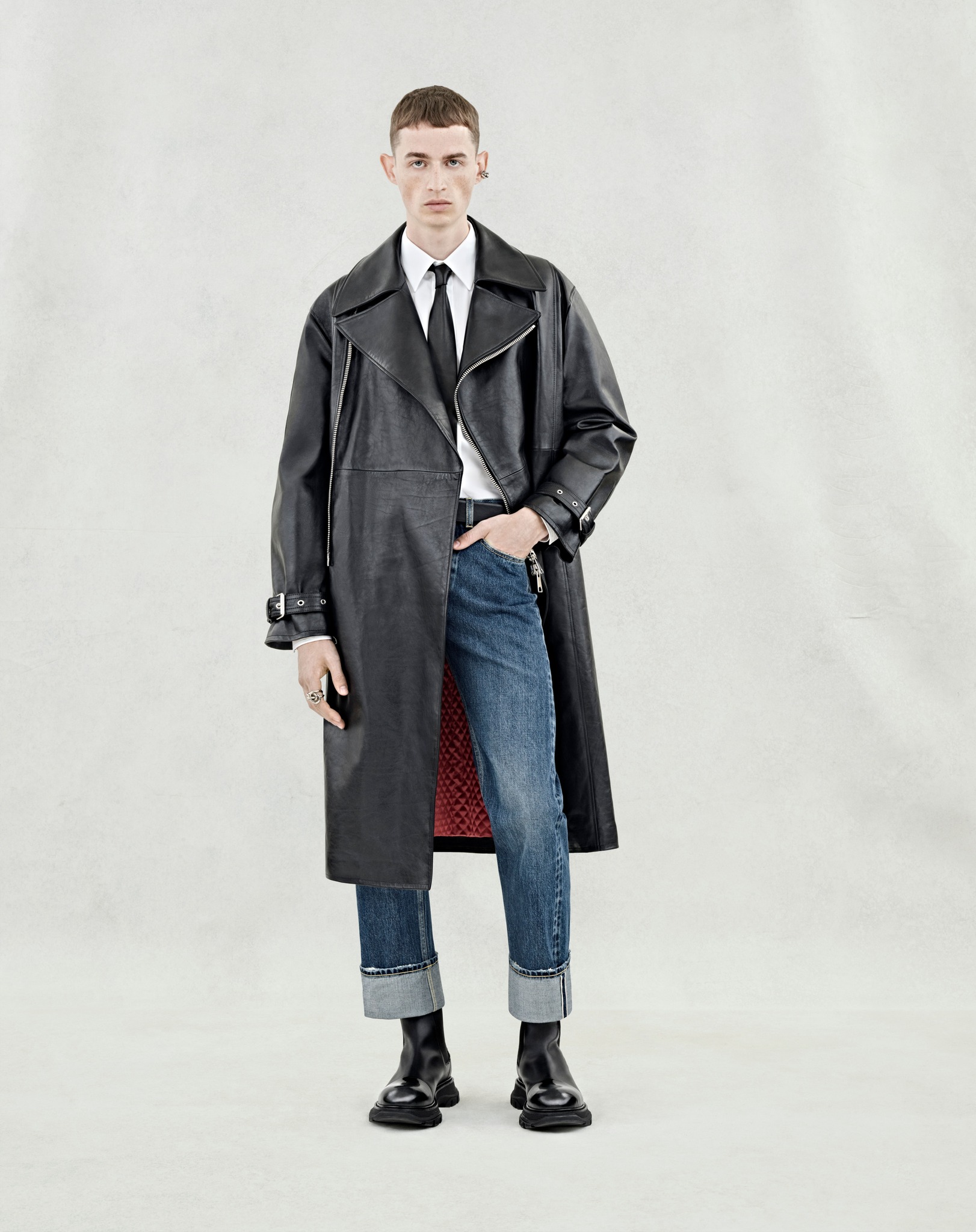 Alexander - A black trench coat with silver metal zip detailing 