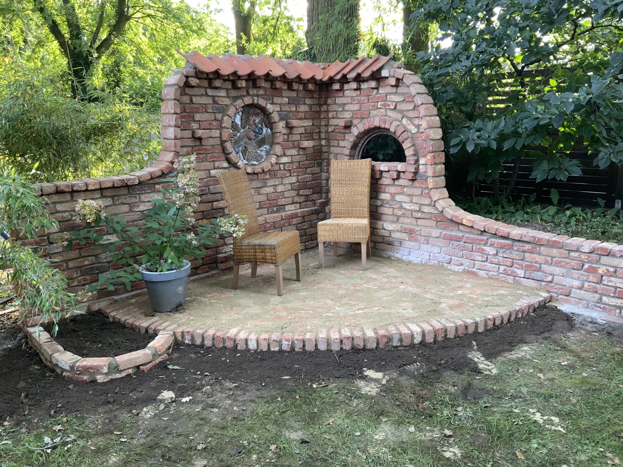 Eine romantische Sitzecke im Garten, umgeben von viel Grün werden hier zukünftig viele gemütliche Stunden verbracht werden. 🌳🧱🌳