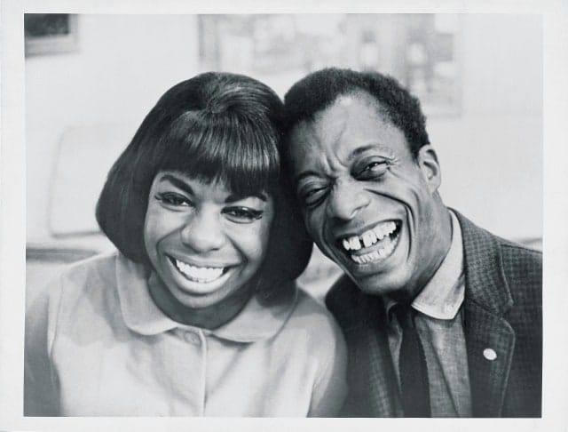 Toni Morrison and James Baldwin sharing a joyful embrace outdoors