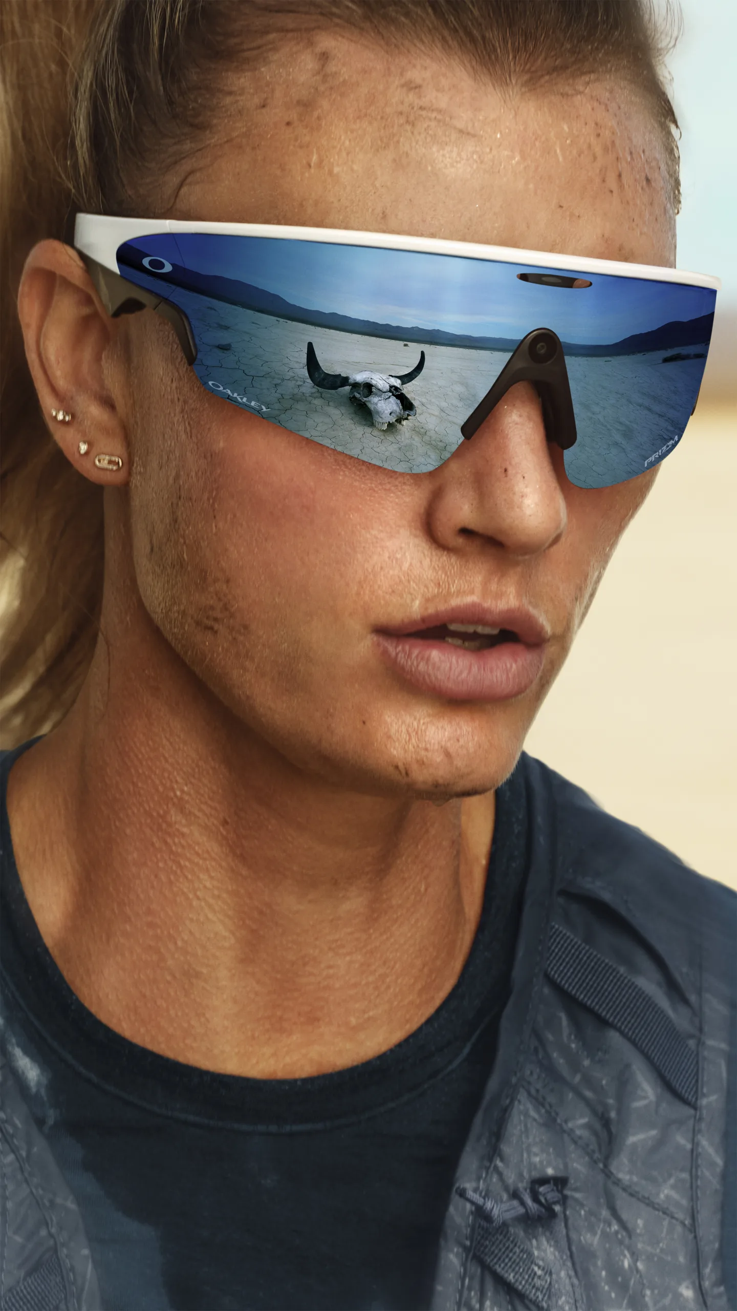 Runner wearing Oakley Meta glasses on a road in Big Sky scenery.