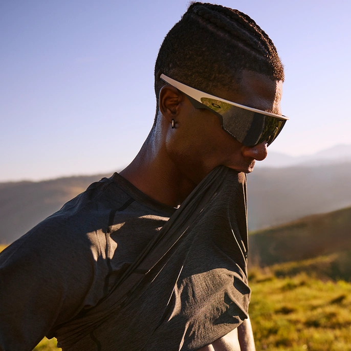 Athlete wearing Oakley Meta Vanguard glasses hold up his shirt to cool off.
