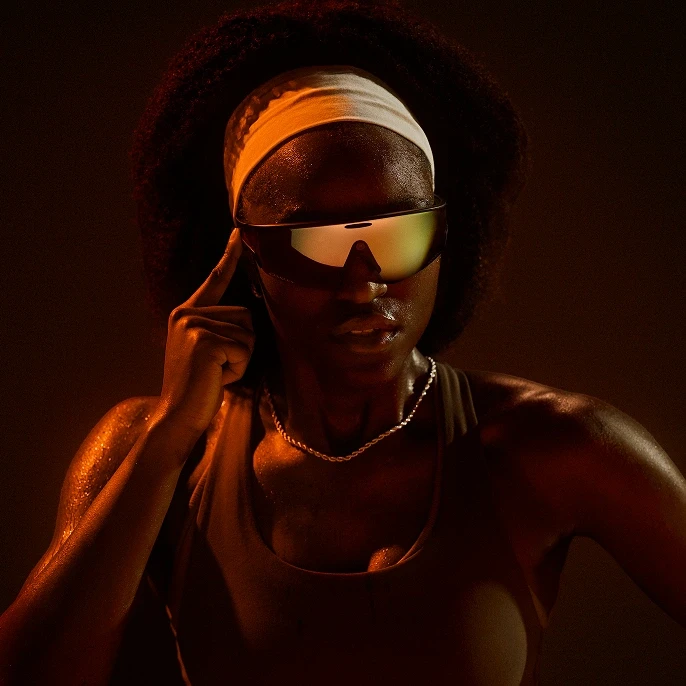 Woman tapping the frame of her Oakley Meta Vanguard glasses.
