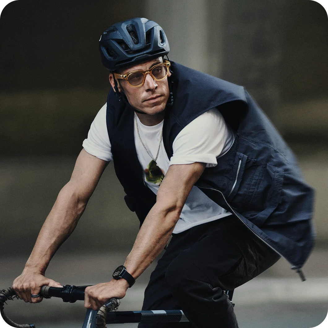 Cyclist taking a hands-free call mid-ride while wearing Ray-Ban Meta Wayfarer sunglasses with yellow lens.